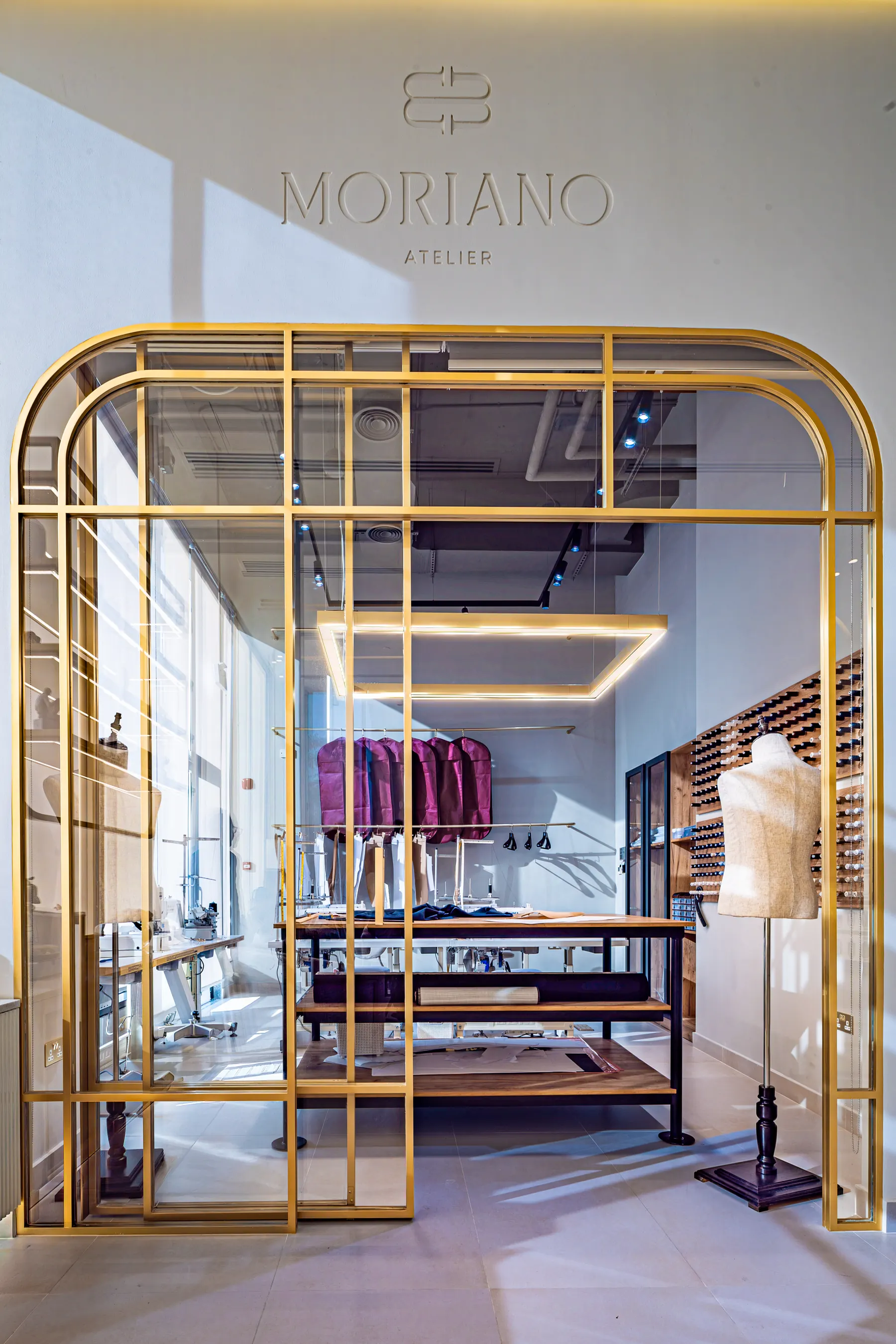 The MORIANO workroom behind its brass and glass arch