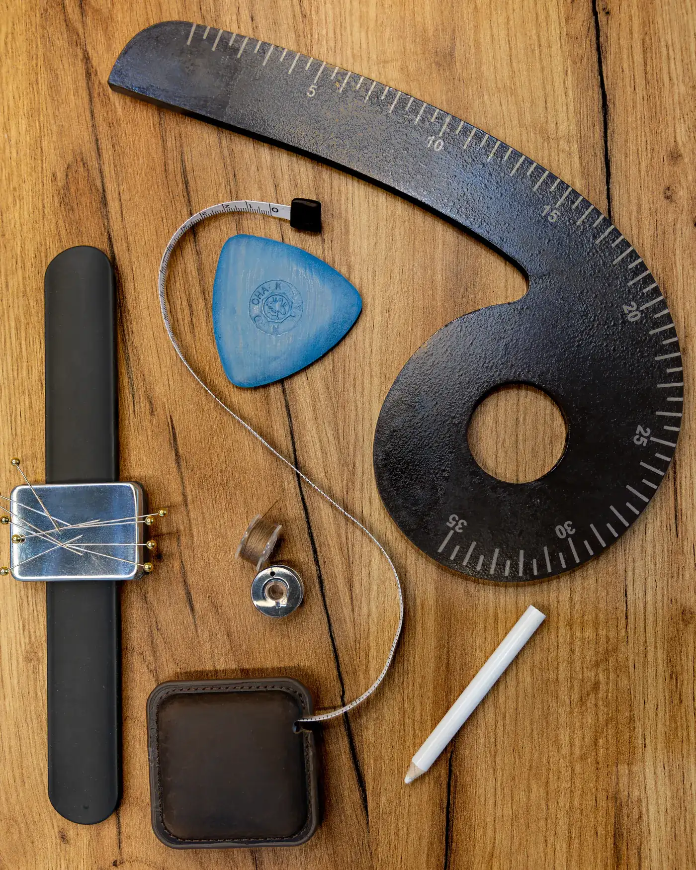 Tailor's shears, chalk and thimble on dark cloth