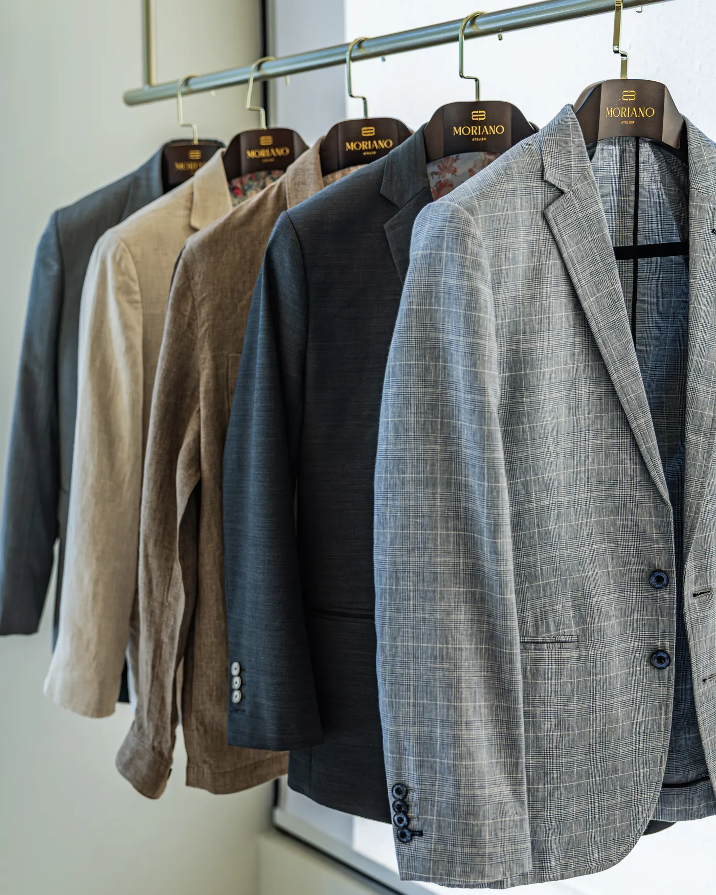 Tailored jackets resting on the atelier rail